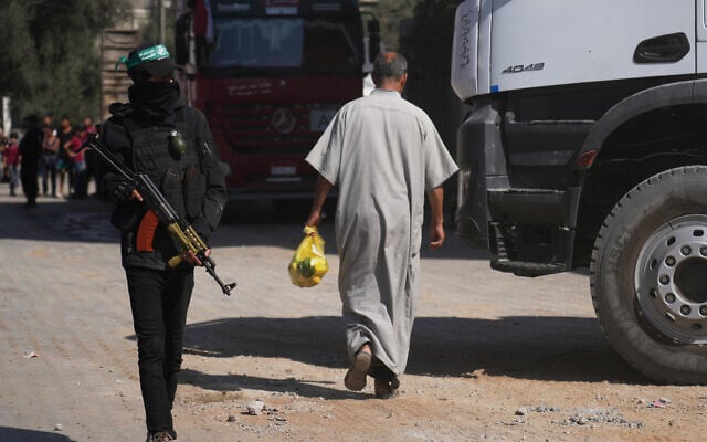Members of the al-Qassam Brigades, the military wing of Hamas, stand at the site where they, along with Egyptian workers and machinery, claim to be searching for the bodies of hostages in Nuseirat, Gaza Strip, October 28, 2025. (AP Photo/Abdel Kareem Hana)