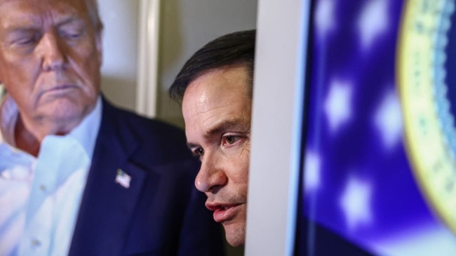 US Secretary of State Marco Rubio speaks to reporters as U.S. President Donald Trump stands next to him aboard Air Force One en route to Tokyo, Japan, for the second stop on his Asia tour, October 27, 2025. (photo: Evelyn Hockstein, Reuters)